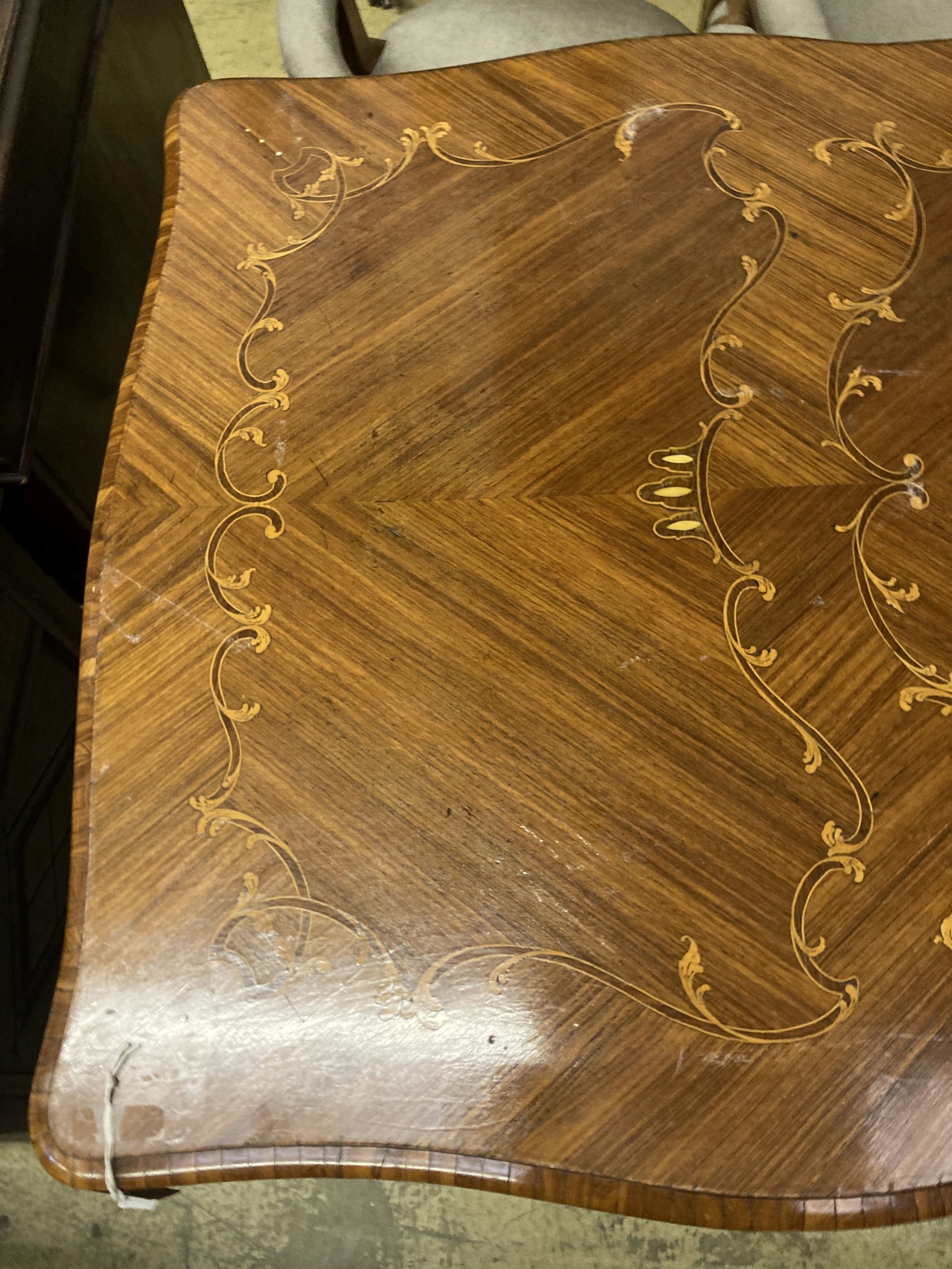 A Louis XVI design marquetry inlaid kingwood serpentine centre table W.196cm. D.90cm. H 79cm.